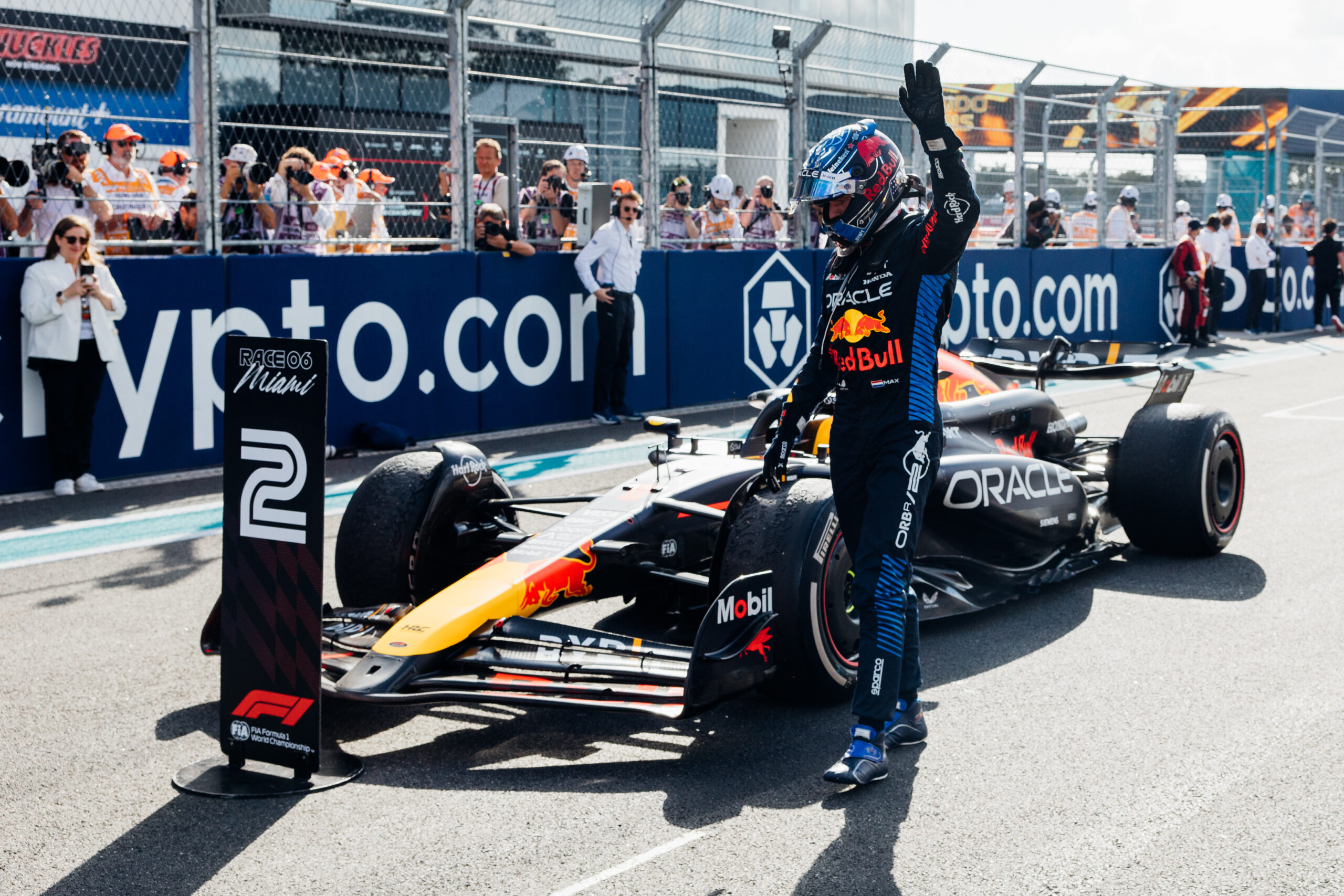 Max Verstappen waves at crowd in next to his racing car