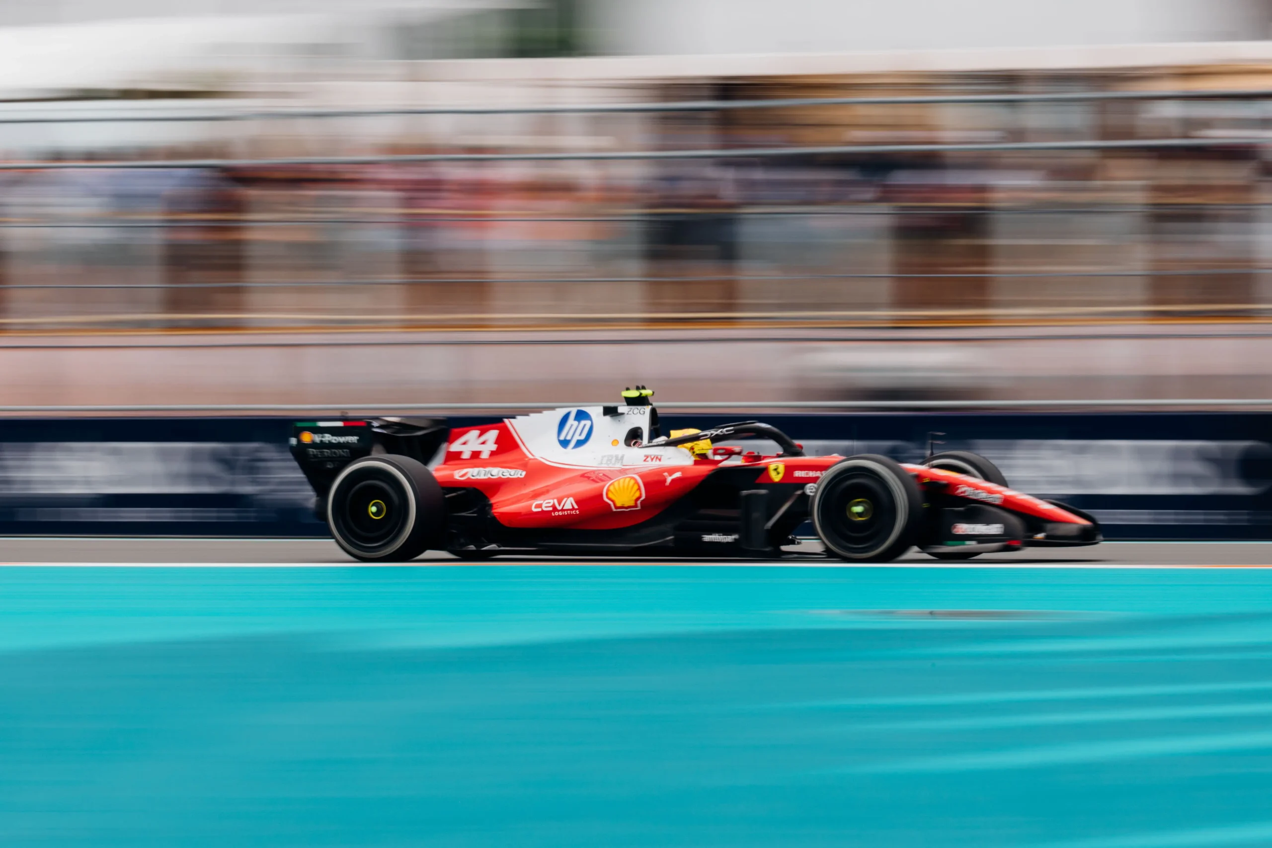 260503_F1MGP_CF9839 Side-on panning shot of a Ferrari Formula 1 car racing through the Miami Grand Prix with motion blur in the background.